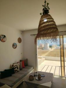 a living room with a couch and a table at Kelibia ezzahra 2min a pied du plage in Ḩammām al Ghazzāz