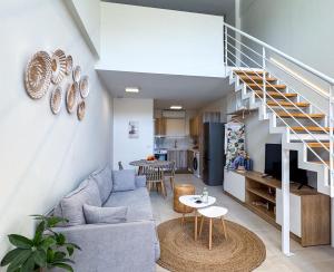 a living room with a couch and a staircase at Thalassa loft in Tolo in Tolo