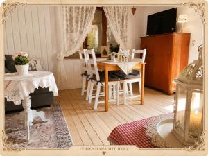 a room with a table and chairs and a television at Emma's Vintage Ferienhaus mit Kamin in Friedrichsbrunn