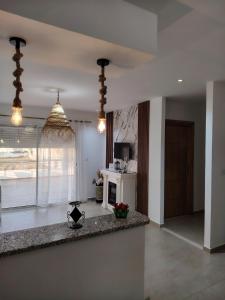 a living room with a kitchen with a counter top at Kelibia ezzahra 2min a pied du plage in Ḩammām al Ghazzāz