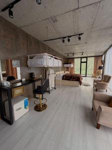 a living room with a desk and a bedroom at Hotel NOA Kazbegi in Kazbegi
