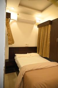 a bed in a room with a window and a bedvisor at BVR Dazzle Residency in Avanigadda