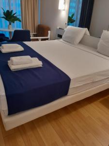 a large bed with two folded towels on it at ა ბლოკი in Stantsiya Batumi-Passazhirskaya