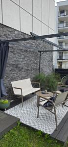 a patio with a table and chairs and an umbrella at Apartament z ogrodem Cyprysowy zakątek in Oświęcim +8 photos