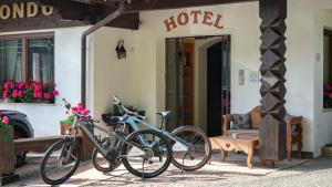 two bikes are parked outside of a hotel at Hotel Condor in Selva di Val Gardena