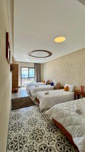 a row of beds in a hotel room at Adventurekeys Surf Yoga Cowork in Taghazout +95 photos