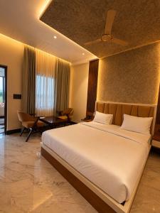 a bedroom with a large white bed and a table at Vianara's Eco Feel Resort in Jaipur +20 photos