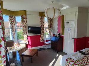 a bedroom with a bed and a room with a tv at Earlston House in Paignton