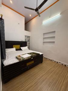a bedroom with a bed with a ceiling fan at Shri Raghuveer guest house in Ayodhya