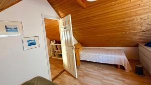a bedroom with a bed and an open door at Nýlenda - Charming Two Bedroom Seaside Property, Mountain and Town Views in Seyðisfjörður