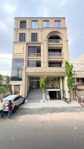 a building with a car parked in front of it at hotel midas in Sāgar