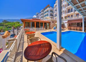 ein Balkon mit Swimmingpool, Tischen und Stühlen in der Unterkunft Medusa Hotel in Kaş