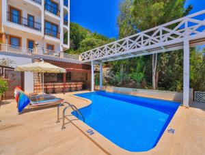Ein Swimmingpool vor einem Gebäude mit einem Sonnenschirm in der Unterkunft Medusa Hotel in Kaş + 44 Fotos