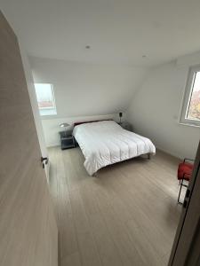 a white bedroom with a bed and a wooden floor at Cozy apartment in Vendenheim in Vendenheim