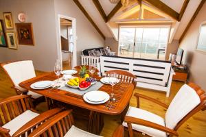 een eetkamer met een houten tafel en stoelen bij Four Seasons Guesthouse in Groot Brak Rivier
