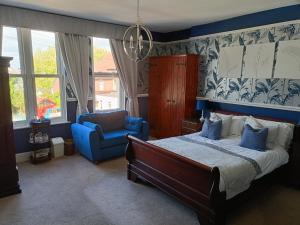 a bedroom with a bed and a blue chair at Earlston House in Paignton