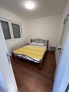a small bedroom with a bed with yellow sheets at Green View in Petrovaradin