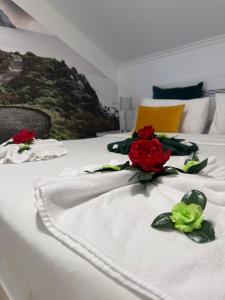 two red and green flowers on a white bed at Palheiro dos 3 A`s in Achadas da Cruz