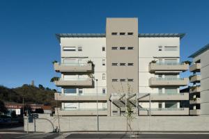 a tall white building with balconies on the side of it at Marcello's Como Lake - Camerlata in Como