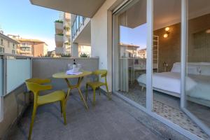 a balcony with a table and chairs and a bed at Marcello's Como Lake - Camerlata in Como