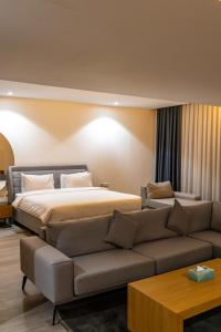 a hotel room with a bed and a couch at فندق بلازا أثينيه Plaza Athenee Hotel in Kuwait +158 photos
