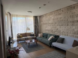 a living room with a blue couch and a brick wall at Dukley residence Lux in Budva