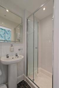 a white bathroom with a sink and a shower at The Rosedene in Llandudno +65 photos