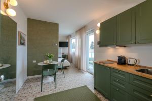 a kitchen with green cabinets and a small table at Marcello's Como Lake - Camerlata in Como