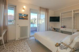 a hotel room with a bed and a desk and window at Marcello's Como Lake - Camerlata in Como