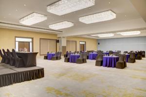 a large banquet hall with purple tables and chairs at Tarangi Resort and Spa in Rāmnagar +97 photos