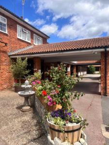 a house with a bunch of flowers in front of it at The Rivenhall Hotel in Rivenhall