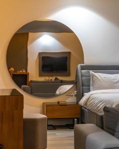 a room with a bed and a couch and a mirror at فندق بلازا أثينيه Plaza Athenee Hotel in Kuwait