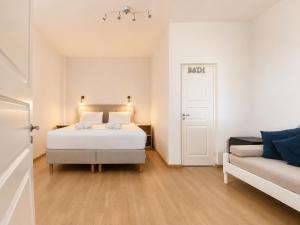 a white bedroom with a bed and a couch at Blue Dolphin Aegina in Vaia +38 photos