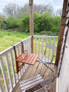 a wooden deck with a table and a chair at Herdsman's Hideaway on the Wye in Fawley Station
