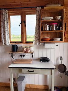 a kitchen with a table and two windows at Herdsman's Hideaway on the Wye in Fawley Station