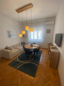 a living room with a table and a couch at Apartment Tiger Lily in Mostar