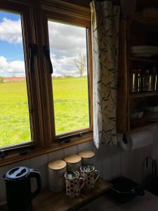a kitchen window with a view of a green field at Herdsman's Hideaway on the Wye in Fawley Station +12 photos