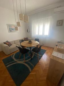 a living room with a table and chairs and a couch at Apartment Tiger Lily in Mostar