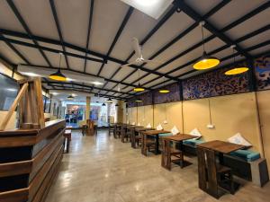 a row of tables and benches in a restaurant at Trinco Beach by DSK in Trincomalee