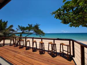 a row of stools sitting on a deck near the beach at Trinco Beach by DSK in Trincomalee