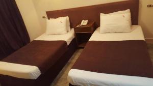a hotel room with two beds and a phone at New Sandy Hotel in Marsa Matruh
