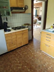 a kitchen with wooden cabinets and a stove top oven at Petit cocon connecté à la nature ! in Pouxeux