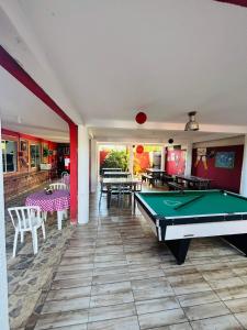 a room with a pool table and some tables at Pousada N'ativaMar in Guaratuba