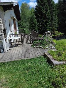a wooden deck with a bench next to a house at Petit cocon connecté à la nature ! in Pouxeux +5 photos