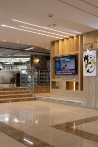 a lobby with stairs and a tv in a building at فندق بلازا أثينيه Plaza Athenee Hotel in Kuwait