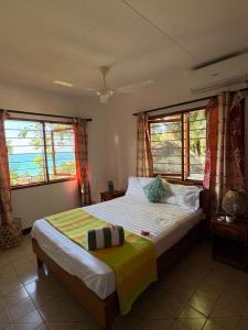 a bedroom with a bed and two windows at Le Rocher De Machabee in Mahe +67 photos