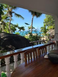 a balcony with a table and a view of the ocean at Le Rocher De Machabee in Mahe