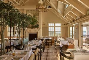 a dining room with tables and chairs and a chandelier at Faraway Sag Harbor in Sag Harbor