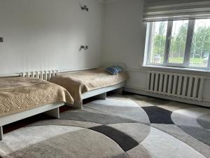 a bedroom with two beds and a window at SunHouse Hostel in Karakol