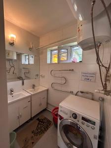 a bathroom with a washing machine and a sink at SunHouse Hostel in Karakol